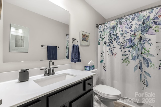 bathroom with curtained shower, vanity, and toilet