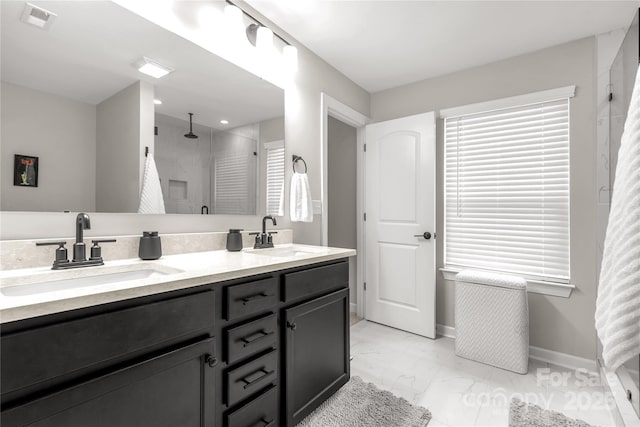 full bath with marble finish floor, a sink, visible vents, and a shower stall