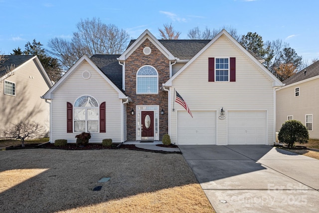 traditional-style house with stone siding, driveway, and an attached garage