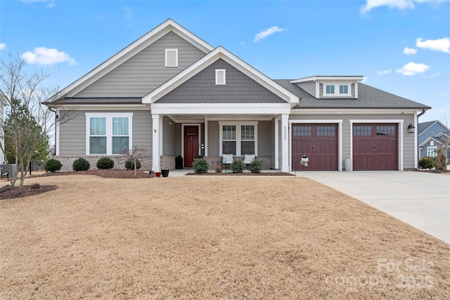 craftsman-style house with a garage, driveway, a shingled roof, and a porch