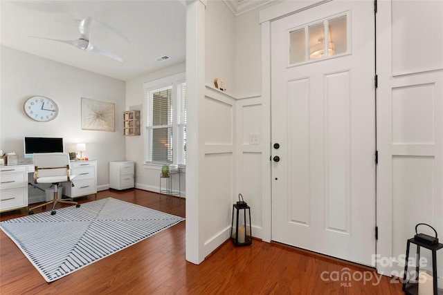 interior space featuring a ceiling fan, baseboards, visible vents, and wood finished floors