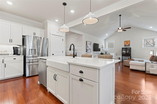 kitchen featuring dark wood-type flooring, a sink, light countertops, appliances with stainless steel finishes, and pendant lighting