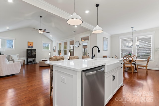 kitchen with dark wood finished floors, open floor plan, a sink, and stainless steel dishwasher