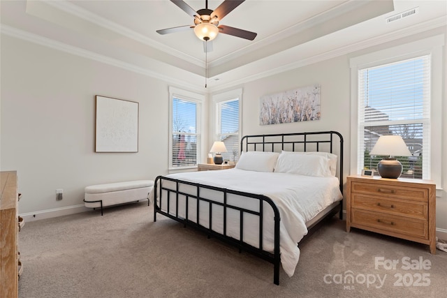 bedroom featuring carpet, a raised ceiling, and crown molding