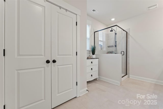 bathroom with a stall shower, visible vents, vanity, and baseboards