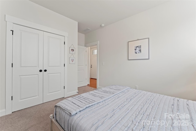 carpeted bedroom with baseboards and a closet