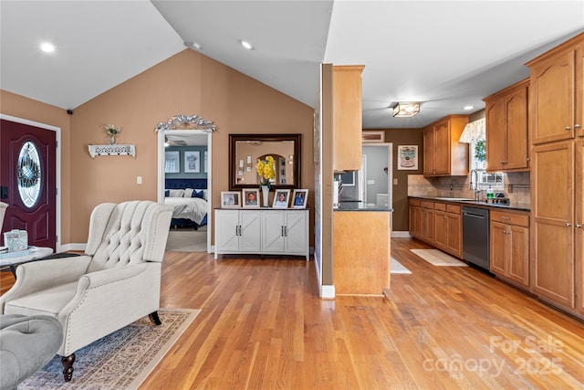 kitchen with open floor plan, brown cabinetry, dark countertops, and dishwasher