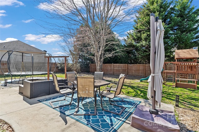 view of patio / terrace featuring a trampoline, outdoor dining area, and a fenced backyard