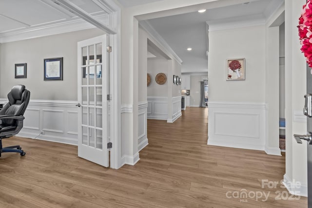 office area with a wainscoted wall, recessed lighting, a decorative wall, ornamental molding, and light wood-type flooring