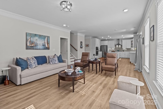 living area featuring plenty of natural light, ornamental molding, stairway, and light wood-type flooring