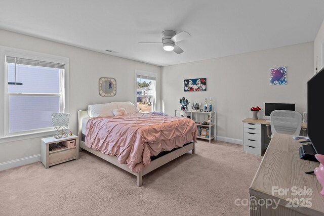 bedroom featuring a ceiling fan, light colored carpet, and baseboards