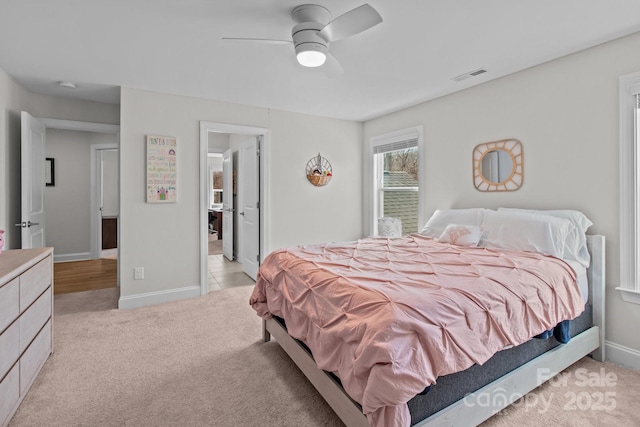 bedroom featuring light carpet, a ceiling fan, visible vents, and baseboards