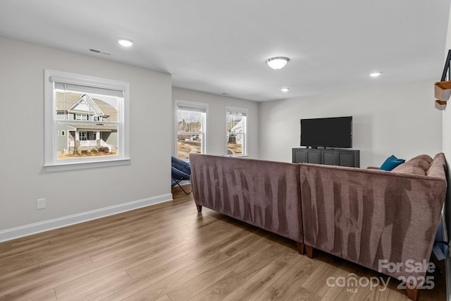 living room with light wood-type flooring, baseboards, visible vents, and recessed lighting