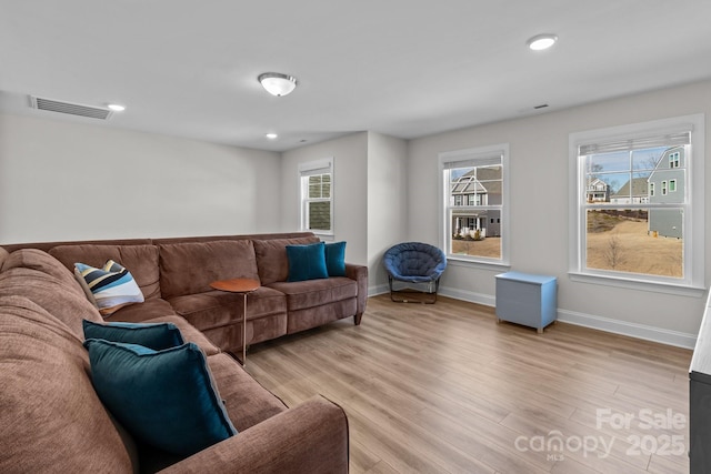 living room featuring light wood finished floors, baseboards, visible vents, and recessed lighting