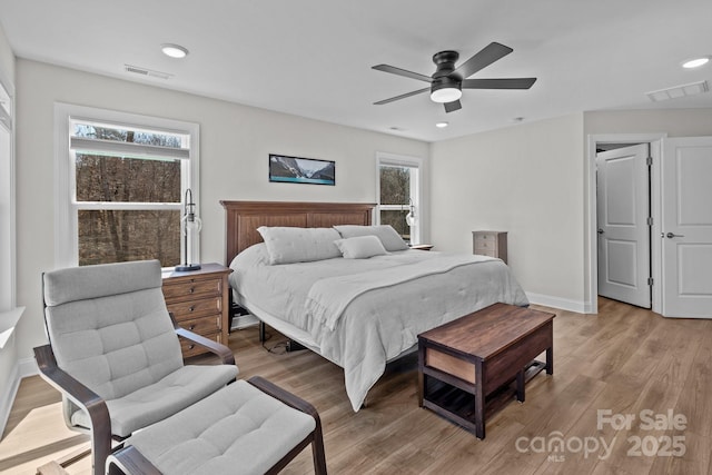 bedroom with a ceiling fan, baseboards, visible vents, and light wood finished floors