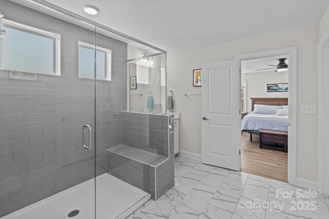 ensuite bathroom featuring a stall shower, baseboards, a ceiling fan, ensuite bathroom, and marble finish floor