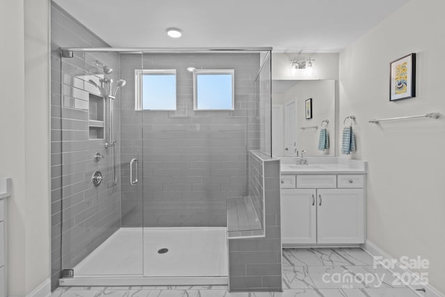 full bathroom featuring marble finish floor, vanity, baseboards, and a shower stall