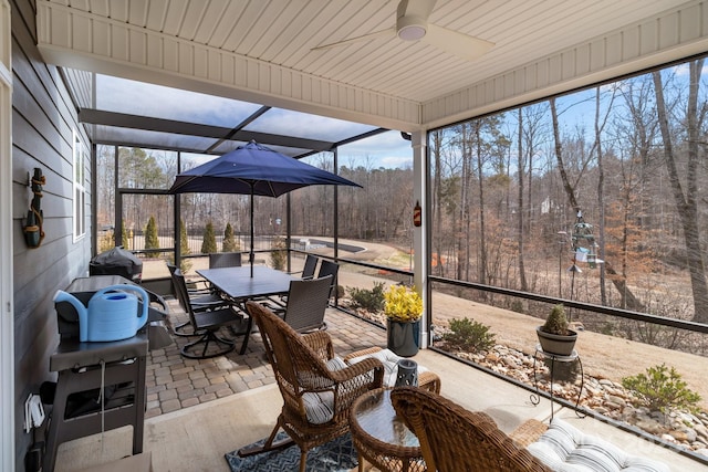 sunroom / solarium featuring a ceiling fan