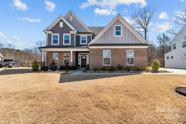 craftsman-style house featuring a front yard, a porch, board and batten siding, and brick siding