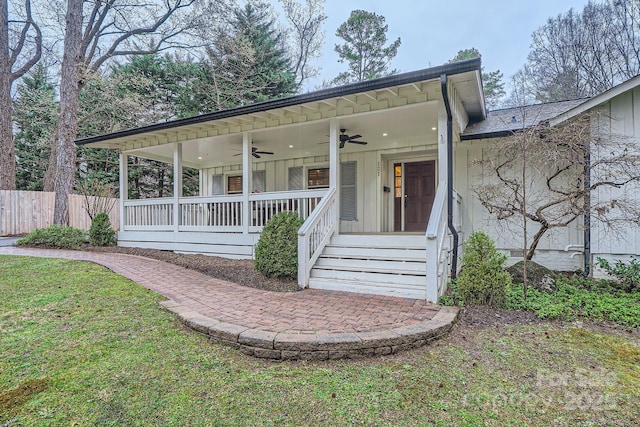 view of front facade with a front lawn, covered porch, a ceiling fan, and fence