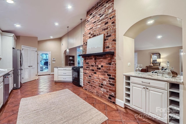 kitchen with white cabinetry, open shelves, arched walkways, and appliances with stainless steel finishes