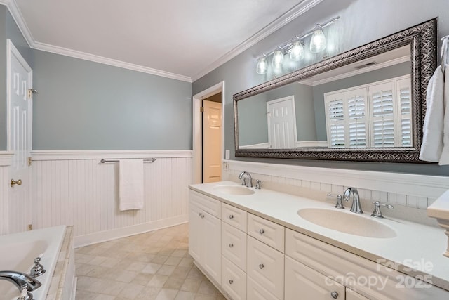 bathroom featuring a sink, a wainscoted wall, double vanity, and crown molding