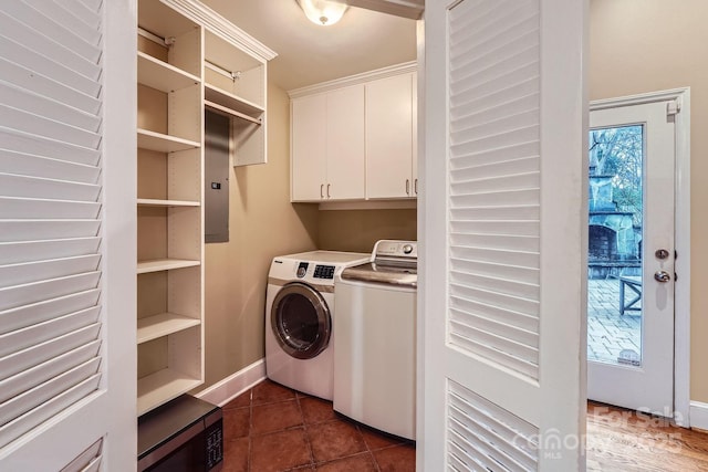 laundry area featuring washer and dryer, baseboards, cabinet space, and dark tile patterned floors