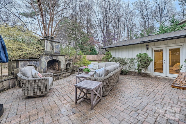 view of patio with french doors, fence, and an outdoor living space with a fireplace