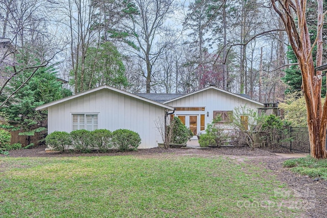 ranch-style home with a front yard and fence