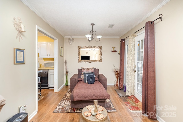 interior space featuring baseboards, ornamental molding, light wood-type flooring, and an inviting chandelier