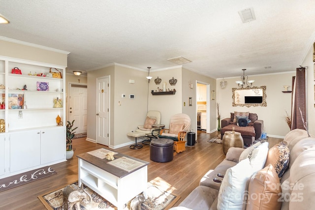 living area with dark wood-type flooring, ornamental molding, and a textured ceiling