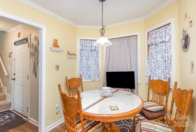 dining space with baseboards, crown molding, stairway, and wood finished floors