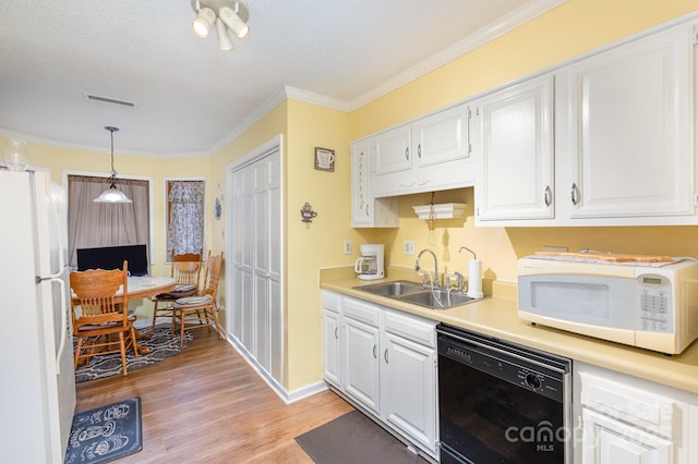 kitchen featuring white cabinets, white appliances, light countertops, and a sink