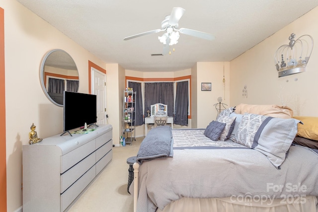 bedroom featuring a ceiling fan, visible vents, and light colored carpet