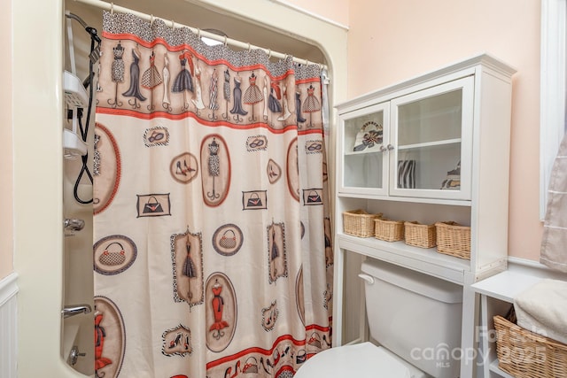 full bathroom with toilet and a shower with shower curtain