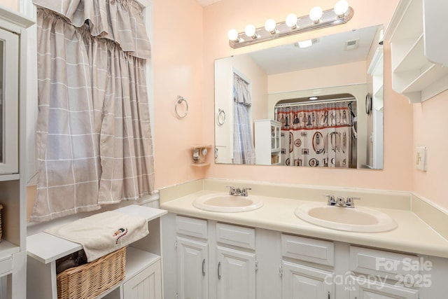 bathroom featuring double vanity, visible vents, and a sink