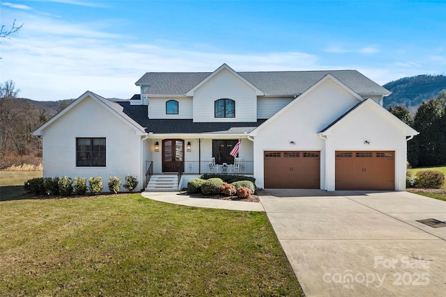 modern inspired farmhouse featuring driveway, an attached garage, a mountain view, a porch, and a front yard