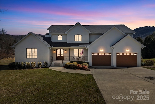 traditional home with covered porch, driveway, an attached garage, and a front yard