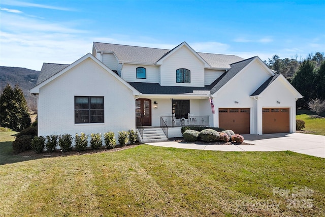 modern inspired farmhouse with concrete driveway, an attached garage, covered porch, a front yard, and brick siding