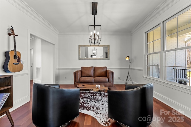 living area featuring baseboards, wood finished floors, visible vents, and crown molding