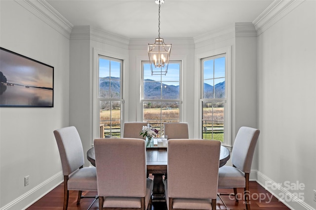 dining area featuring dark wood-style floors, a chandelier, a mountain view, and baseboards