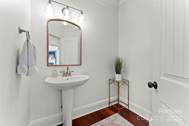 bathroom with a sink, wood finished floors, and baseboards