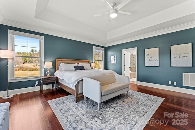 bedroom with dark wood-style floors, baseboards, visible vents, and a tray ceiling