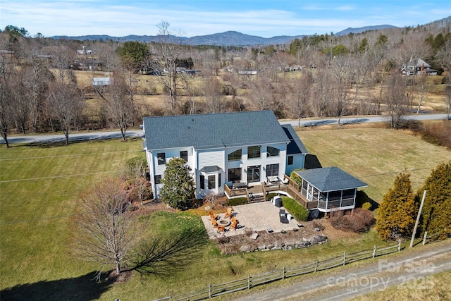 exterior space with a mountain view, fence, and a sunroom