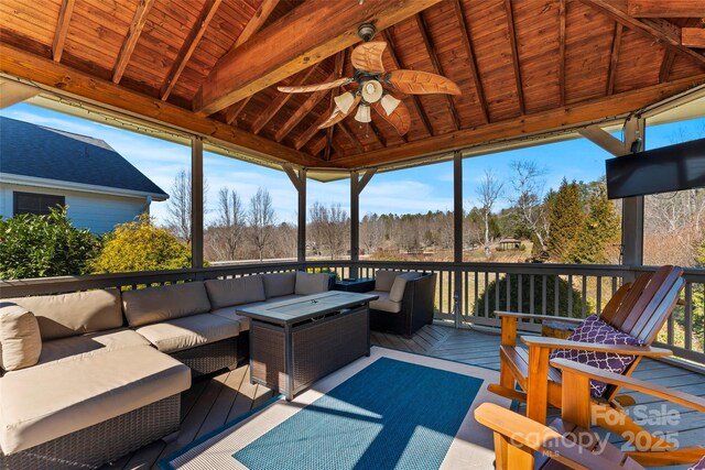 exterior space featuring lofted ceiling with beams, wooden ceiling, and a ceiling fan