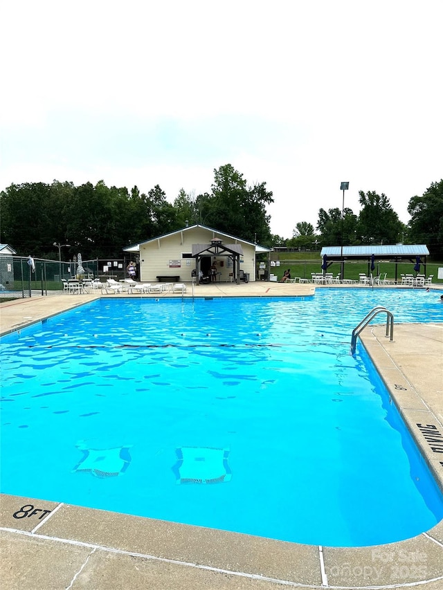 community pool featuring a patio area and fence