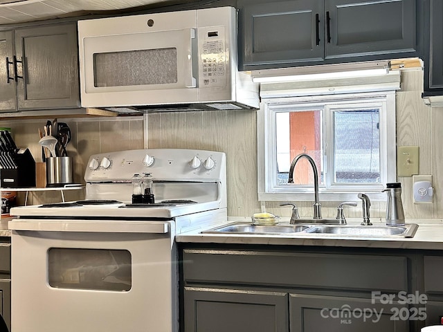 kitchen featuring light countertops, white appliances, gray cabinets, and a sink