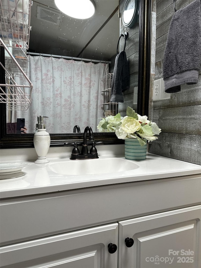 bathroom featuring curtained shower and vanity