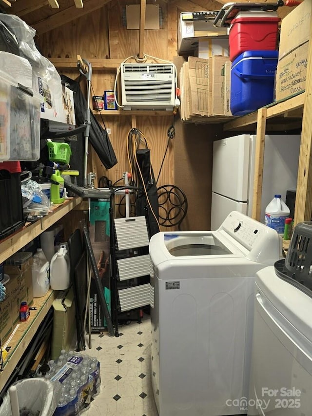 washroom featuring laundry area, tile patterned floors, an AC wall unit, wood walls, and washing machine and dryer