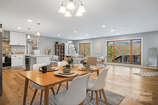 dining room featuring light wood-style flooring, a chandelier, and recessed lighting